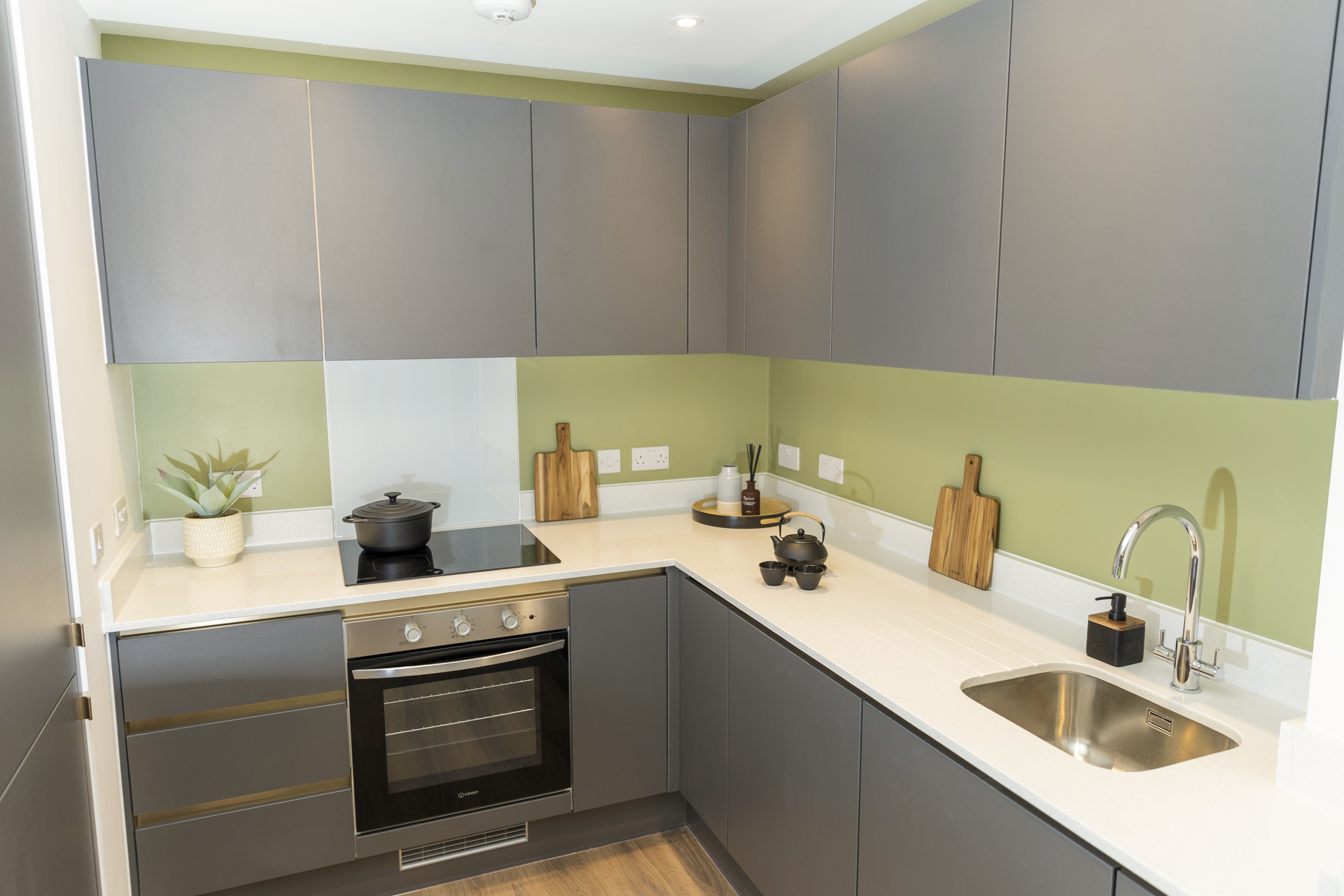 A photograph showing a furnished kitchen, including built-in units and applicances.