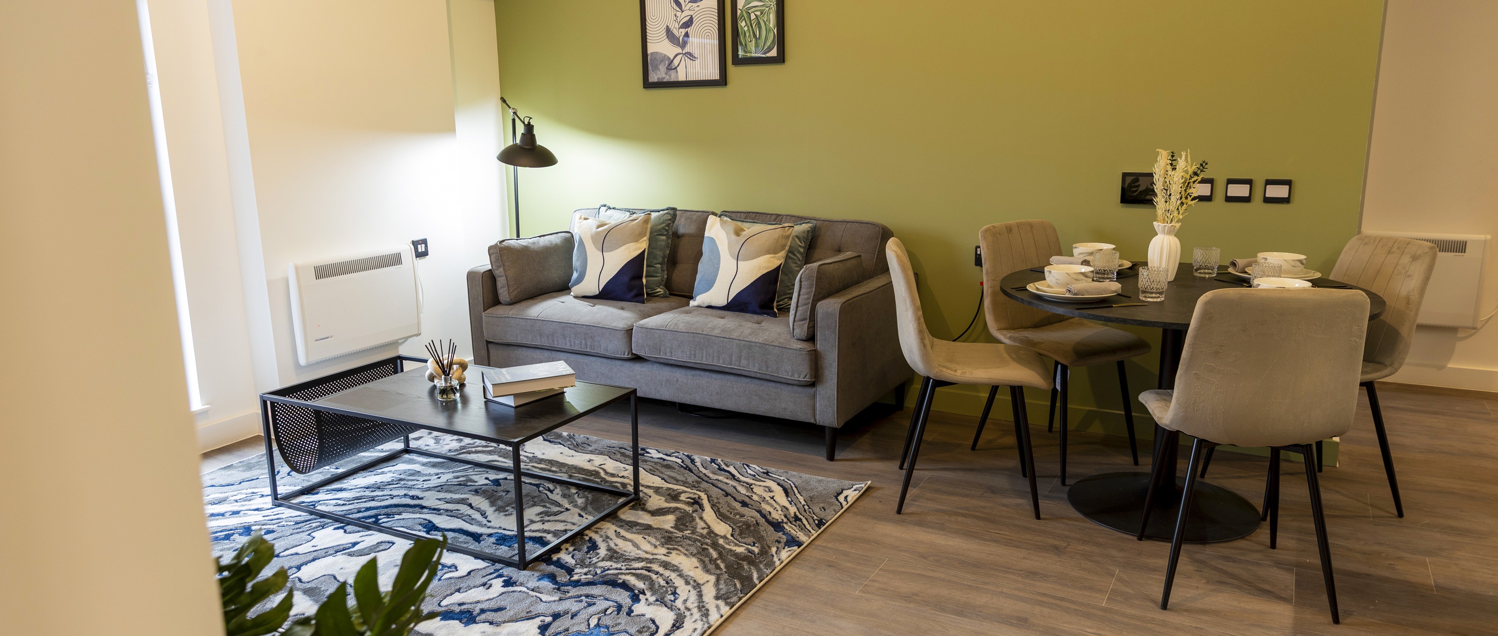 An photograph showing the open plan furnished living room and dining room.