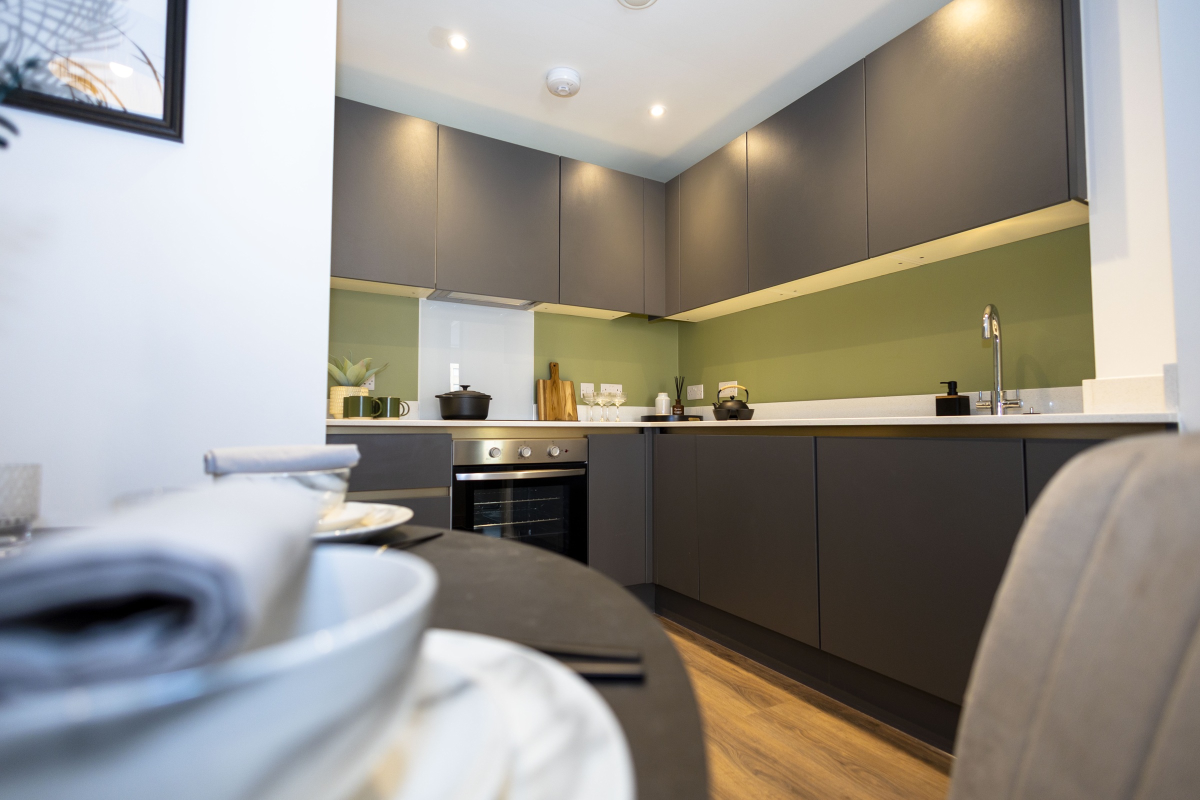 A photograp showing an open plan kitchen from the perspective of the dining table.
