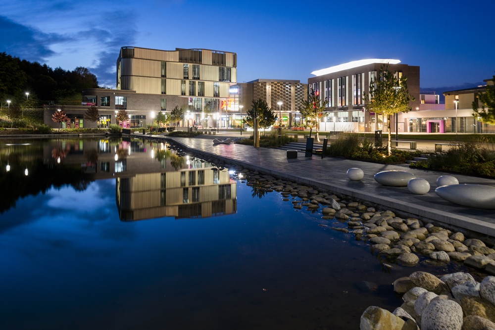 A photograph showing Southwater Lake and the surrounding building at night time.