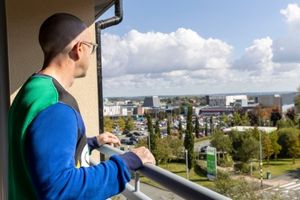 Dan looking out from balcony of new home